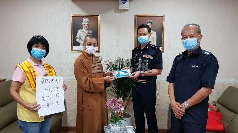 沈润美（左起）与释慧性移交口罩予霹雳州警察总部，由吴文恭代表接领。右一为黄沐发。