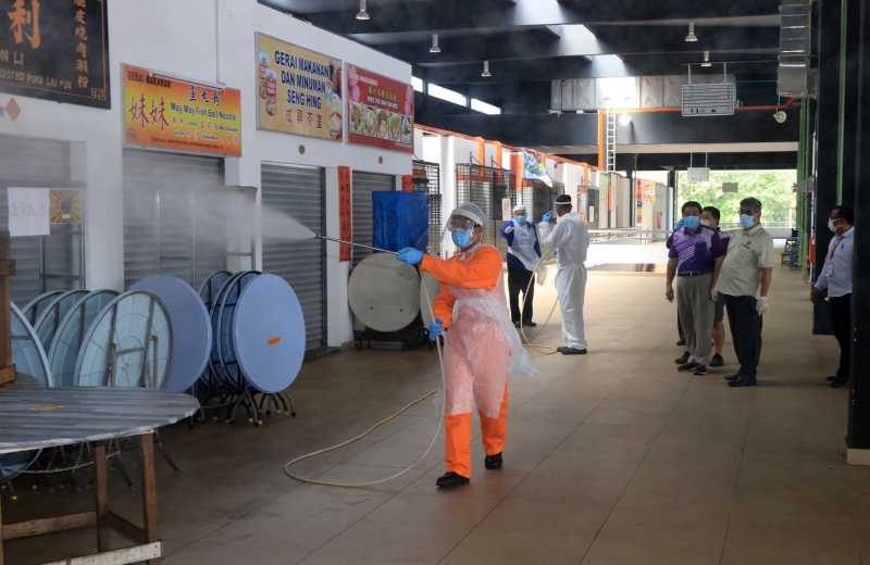 防护人员在芙蓉公市二楼熟食区喷射消毒液。