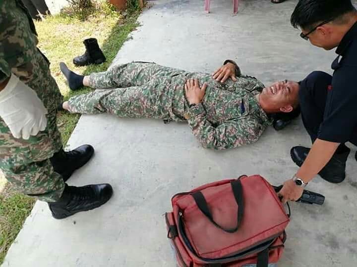 其中一名受伤的军人，躺在地上等待医护人员前来支援。

