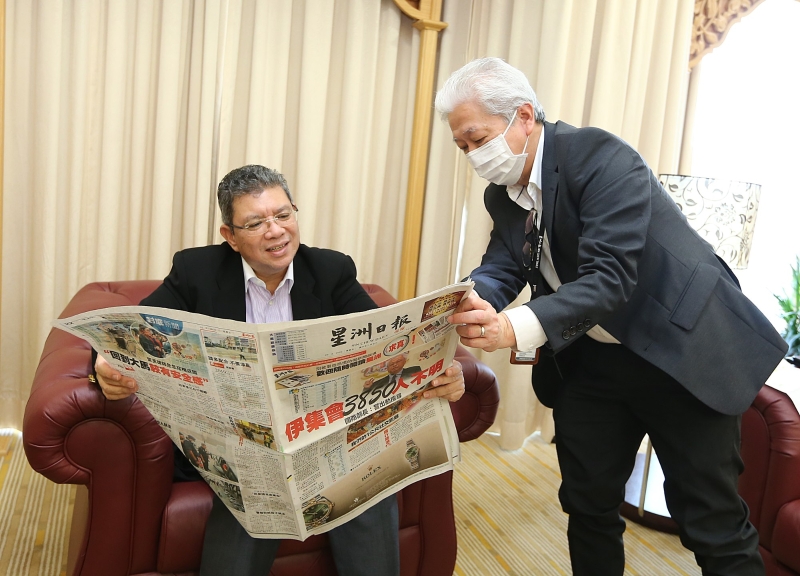 星洲日报总编辑郭清江（右）向赛富丁展示“求真”版的内容。