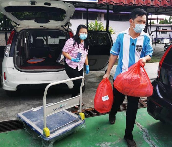 谢琪清（右起）和颜湘玲把捐献给医护人员的干粮食品，载到端姑查化医院。