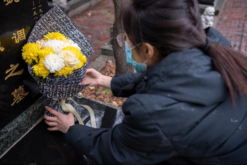 在太原市仙居园公墓，提供代祭服务的工作人员在敬献鲜花。（图：新华社）