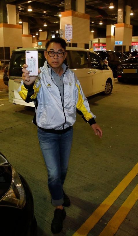 戴志伟拿出手机反拍跟拍的港媒。