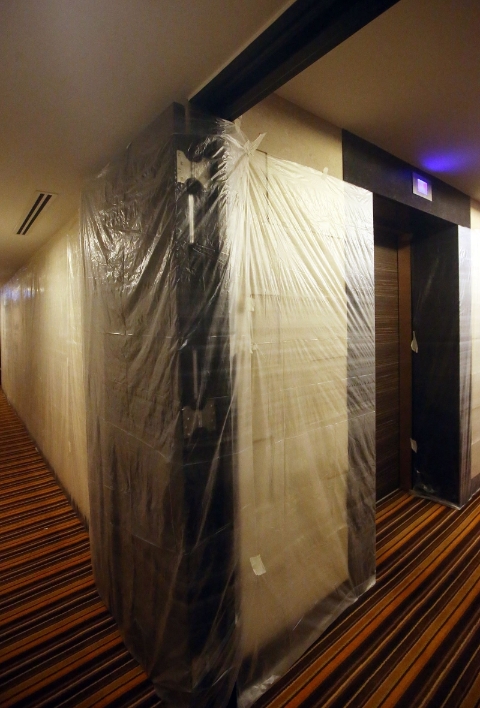 酒店电梯外的墙壁上都被铺上塑料袋，作为预防冠病传播的措施之一。