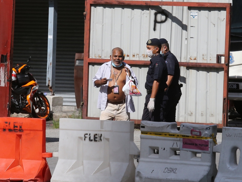 一名穿著不雅的印裔大叔嚷著要带食物给大厦的亲人，但遭军警人员拒绝放行。　