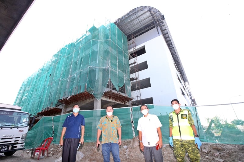 士拉央旧批发公市的新巴刹建筑工程还未完成，预计要年杪才可竣工。前排左起为叶进传、郑秀明及阿都阿兹。