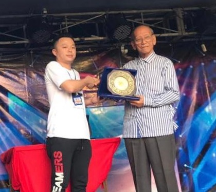 彭立仁（左）赠送纪念品给“浪爱义起”慈善夜跑的主要赞助人陈孟通。