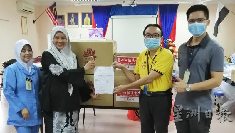 刘纬雄（右二）代表星洲日报基金会和国际佛光会马来西亚协会移交医用品给予依迪丽雅。左一哈兹妮占，右是麦为权。