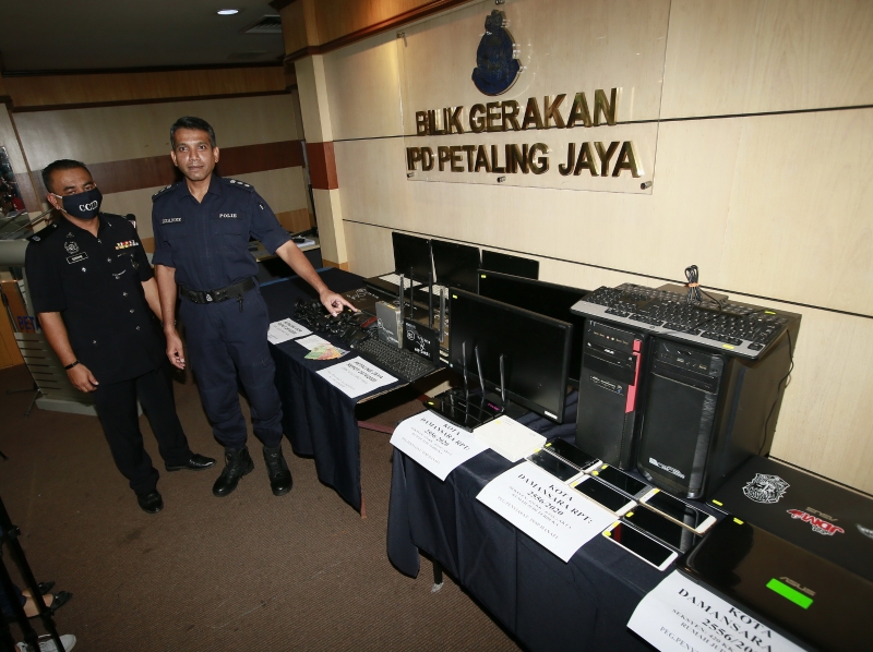 聂依查尼向记者展示警方起获的电脑、手提电脑、手机等网赌器材。