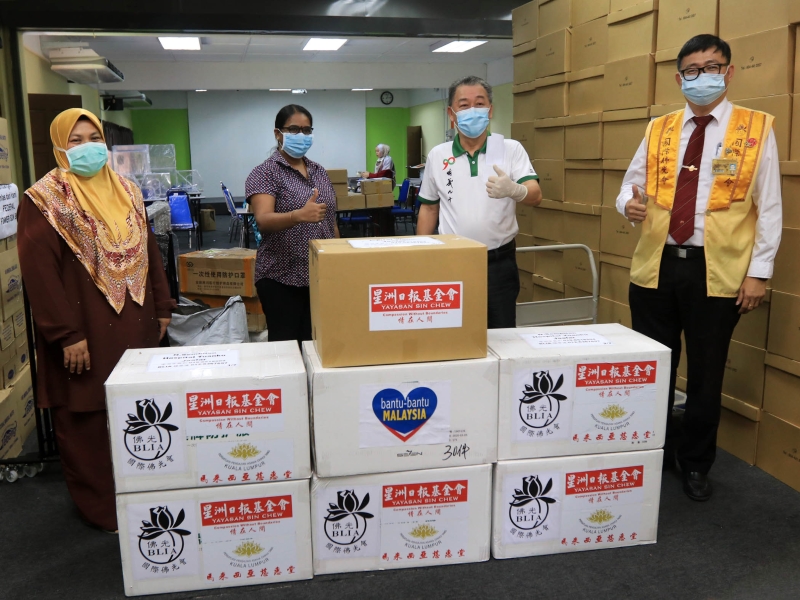 诺阿兹丽娜（左起）及拉吉，感谢星洲日报基金会和国际佛光会马来西亚协会，为医院送上防护衣，右起为许炳全和李意和。