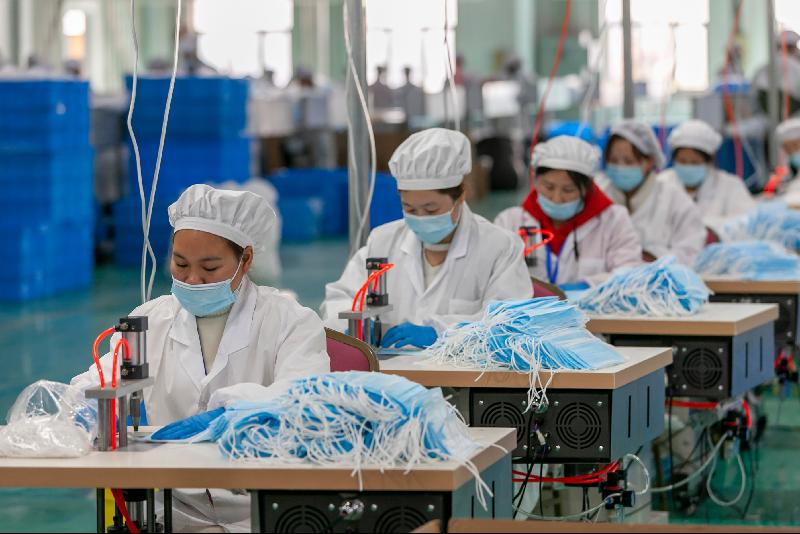 在上海市浦东新区三枪工业城口罩生产车间，工作人员在生产口罩。（图：新华社）