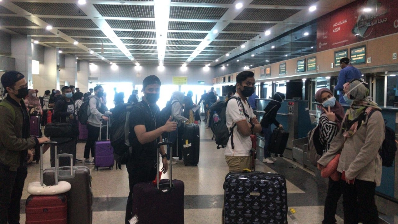 留学埃及的大马学生在开罗国际机场办理登机手续时，奉行安全社交距离，队伍之间相距1公尺。