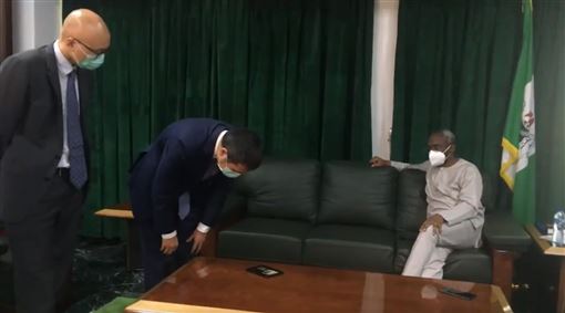 在网传视频中，中国驻尼日利亚大使周剑平（左二）在见到该国众议院议长时，俯身看手机视频的动作被误传为“鞠躬道歉”。（图：互联网）