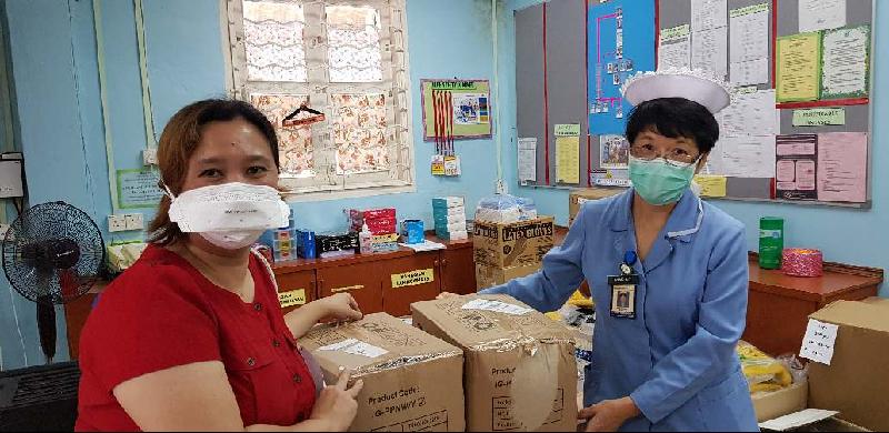 
古晋博爱协会秘书蔡心玲（左）把义工缝制的防护衣及制作的面罩移交给砂中央医院的护士。