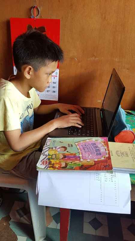 打里卜公民小学土著学生雷希使用副校长张少纶的电脑，参与线上学习。