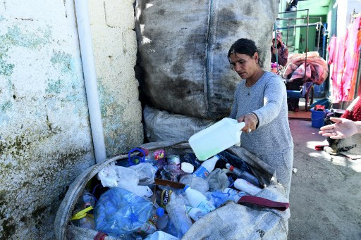 48 year-old Lindita Vogli arranges plastic bottles placed in big bags at the entrance of her house in Breglumas village near Tirana. AFP 48 year-old Lindita Vogli arranges plastic bottles placed in big bags at the entrance of her house in Breglumas village near Tirana. AFP