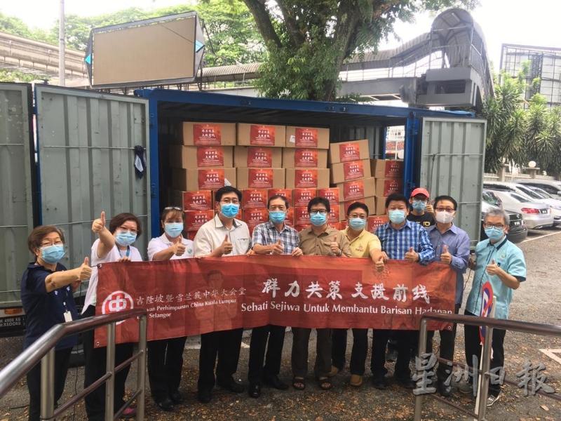 翁清玉（左五）等人运送医疗物资到各大医院前合照。（图：星洲日报）
