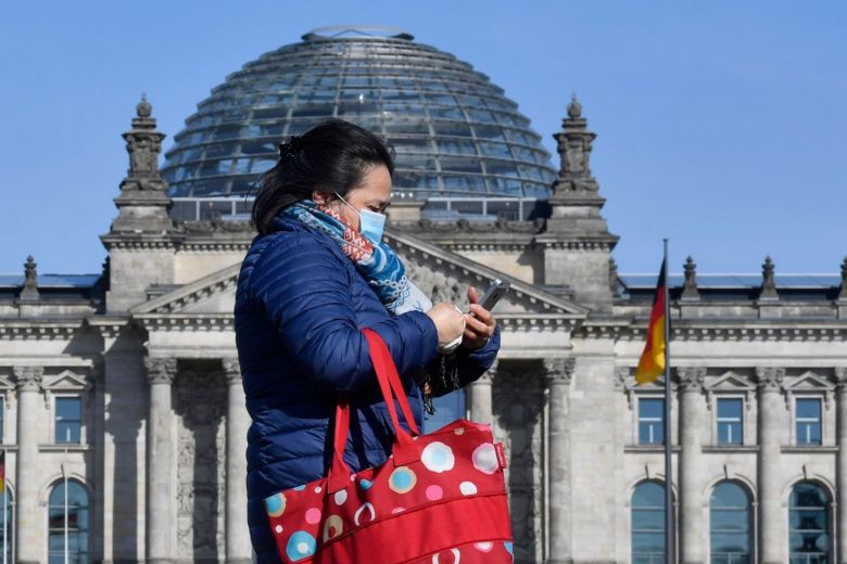 A woman walks past the Reichstag in Berlin. AFP