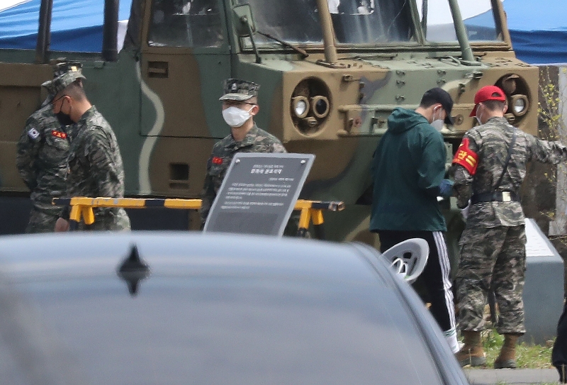 孙兴慜在（右二）周一已向济州道海军陆战队第九旅的训练营报到，开始接受为期3周的基本军事训练，他在入营时穿着一件绿色夹克，戴着黑色棒球帽，并且佩戴了口罩。（图：法新社照片）