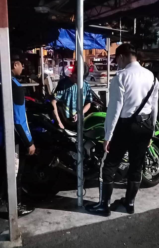 交警检查青年在飙车时使用的摩哆车。