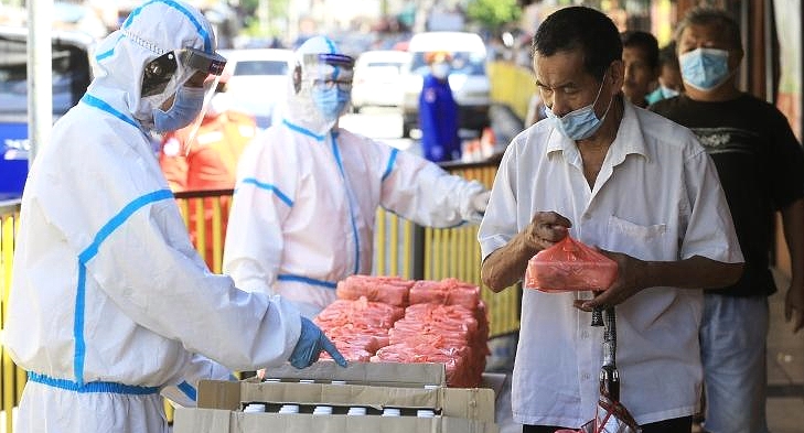 Volunteers put on protective equipment before distributing the food. SIN CHEW DAILY Volunteers put on protective equipment before distributing the food. SIN CHEW DAILY