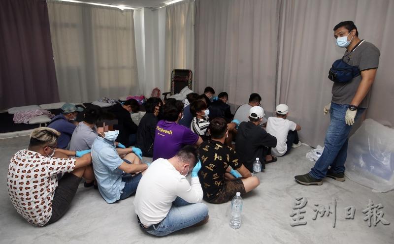 被捕男子被集中坐在一角，等待被押返警局。