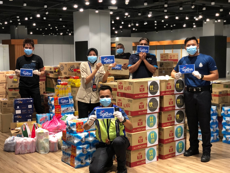 MyTOWN购物中心代表与马来亚大学医药中心成员准备各种物资，作为前线人员抗疫用途。