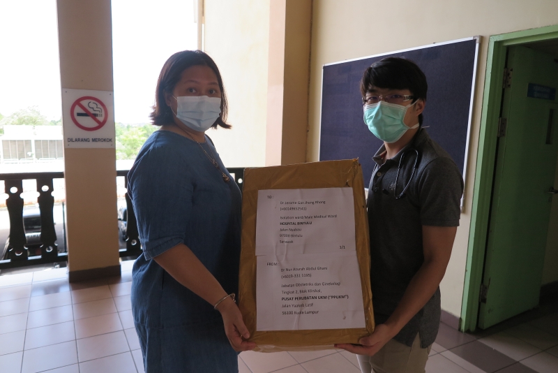 梁安妮（左）移交口罩予颜程荣医生。
