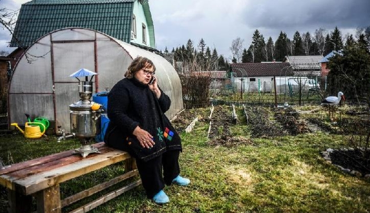 School teacher Nataliya Sapiga talks on the phone in her dacha yard. AFP School teacher Nataliya Sapiga talks on the phone in her dacha yard. AFP