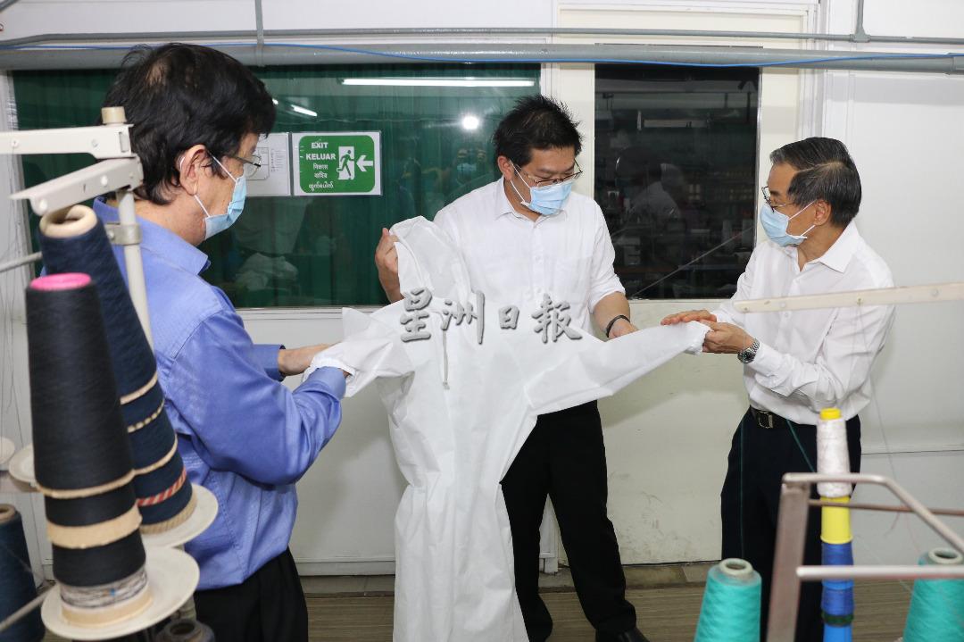 陈天保（左）和林国文（右起）向林万锋展示将提交卫生部审核的个人医用防护衣。