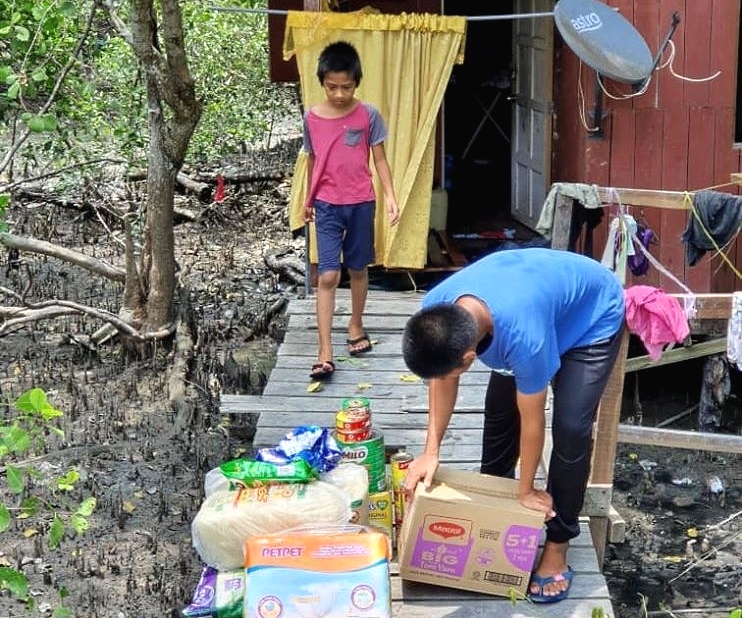 Tan Kok Boon (R) delivers food and other necessities in person to an impoverished family in Klang. Facebook/Ulasan Apek Cina Tan Kok Boon (R) delivers food and other necessities in person to an impoverished family in Klang. Facebook/Ulasan Apek Cina