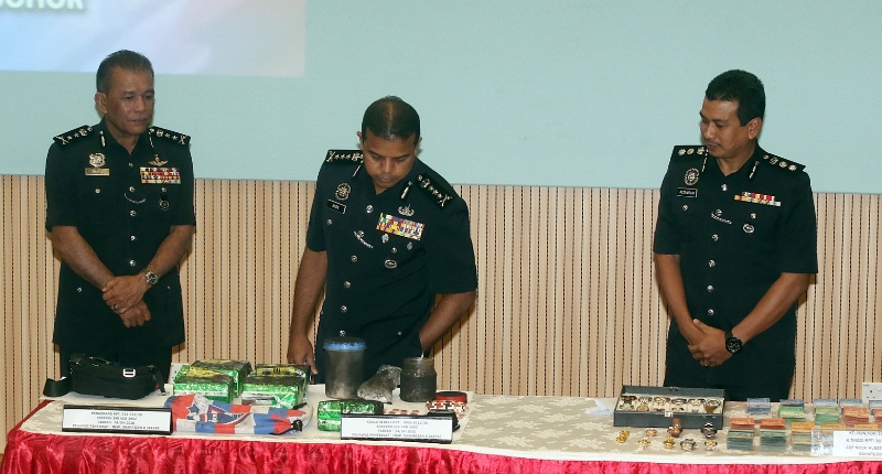 阿育汉（中）展示警方起获的毒品和其它物品；左为沙菲益，右是莫哈末阿夫扎尼占。