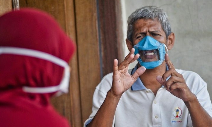 Dwi Rahayu (L) and her husband Elfiandi are among deaf Indonesians using transparent face masks to communicate. AFP Dwi Rahayu (L) and her husband Elfiandi are among deaf Indonesians using transparent face masks to communicate. AFP