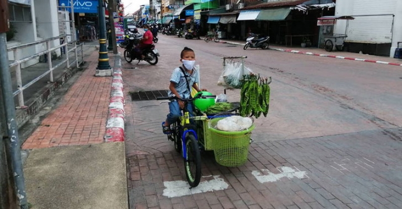 10岁的小童为了分担负担，每天骑三轮车出去卖菜赚钱。