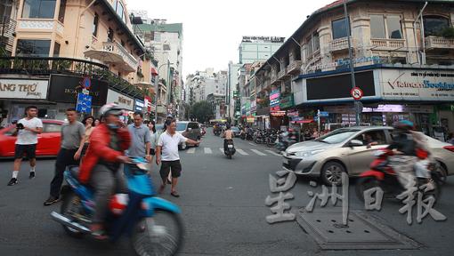 在越南胡志明市，过马路是门艺术。