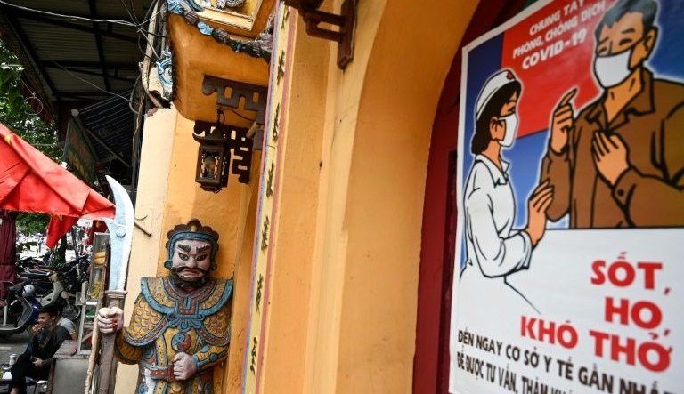 A stylized propaganda poster against coronavirus in the old quarter of Hanoi. AFP A stylized propaganda poster against coronavirus in the old quarter of Hanoi. AFP
