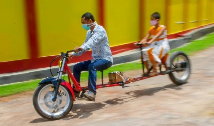 Self-made automobile engineer Partha Saha (L) built a motorbike designed for social distancing. AFP Self-made automobile engineer Partha Saha (L) built a motorbike designed for social distancing. AFP