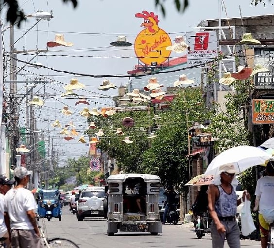 Straw hats hang high above the street shortly after a local festivity. SIN CHEW DAILY