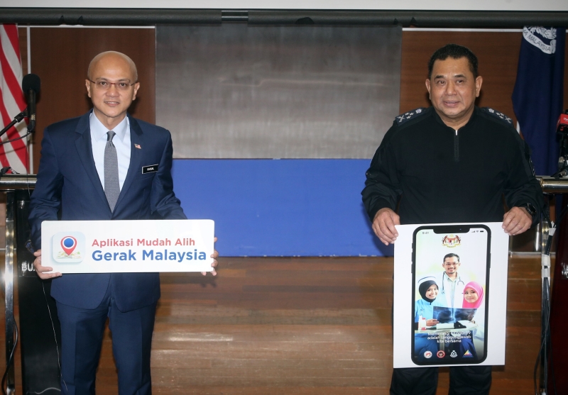 胡兹尔（右）促民众更新Gerak Malaysia手机应用程式版本，以提交跨州申请。旁为阿依沙。