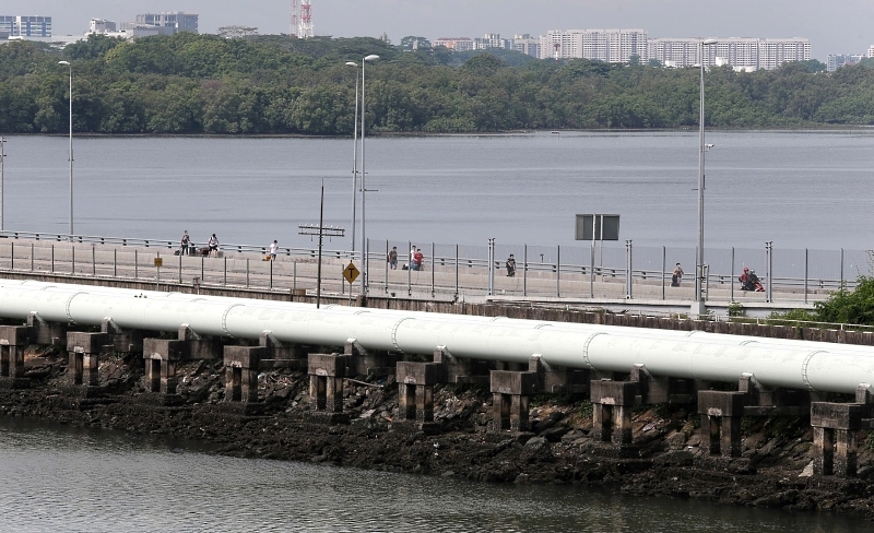 The men tow their luggage cross the Causeway on foot while their wives leave for JB by bus. SIN CHEW DAILY The men tow their luggage cross the Causeway on foot while their wives leave for JB by bus. SIN CHEW DAILY
