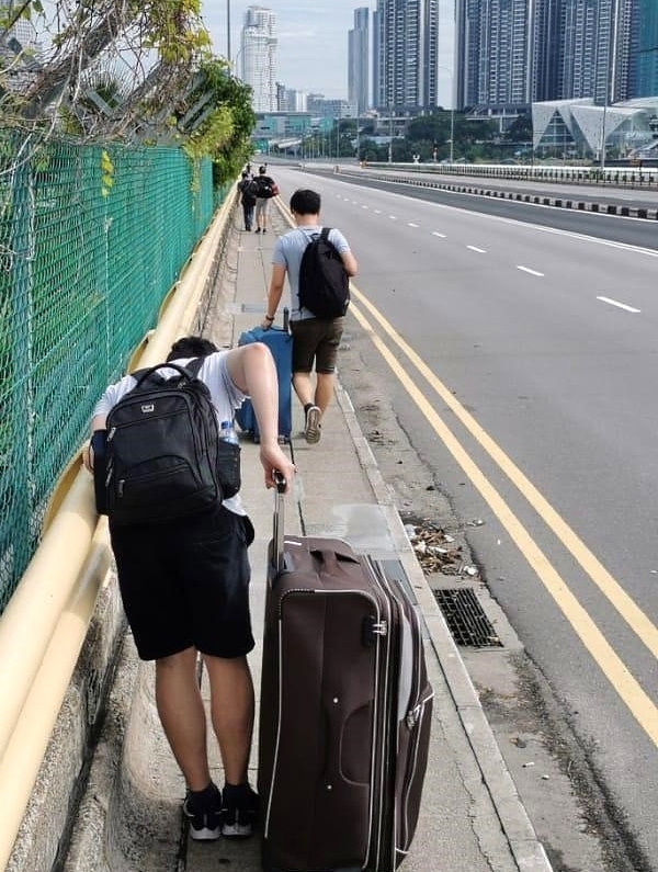 The men spend about 40 minutes walking across the Causeway on foot under the hot sun. SIN CHEW DAILY The men spend about 40 minutes walking across the Causeway on foot under the hot sun. SIN CHEW DAILY