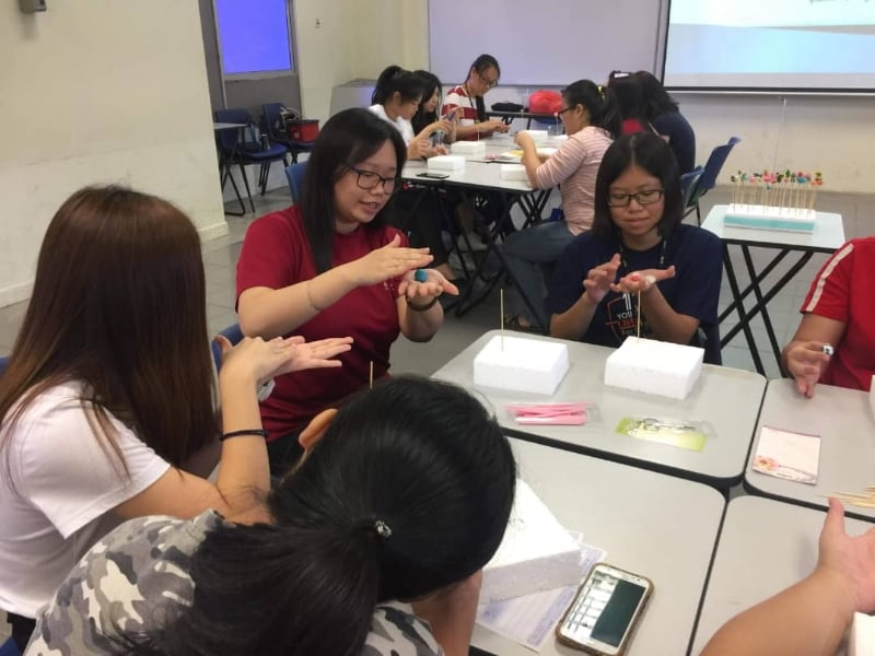 何欣霓（左二）经常在大学里举办捏面人工作坊，让更多年轻一代了解这项艺术。