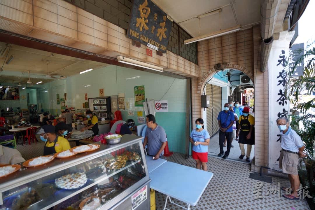 位于怡保杨加森路的永泉茶室印度扁担饭档，吸引许多群众排队等候外带扁担饭。