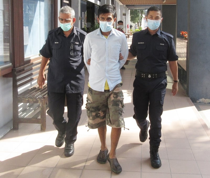 被告兴尼鲁（中）被庭警押上法庭。