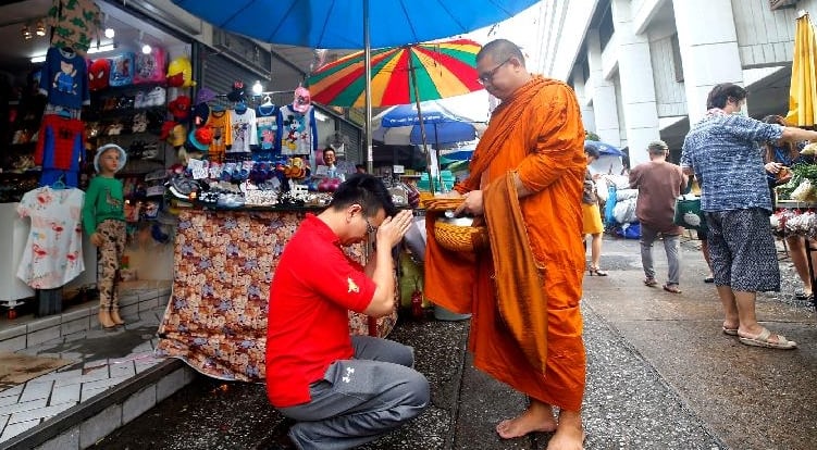 Offering alms to monks has been a daily routine in Thai living. SIN CHEW DAILY