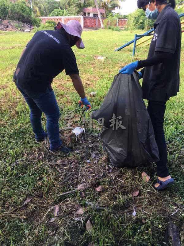 住宅区儿童游乐场地上有不少垃圾，刘峻延的工人将之捡拾起来。
