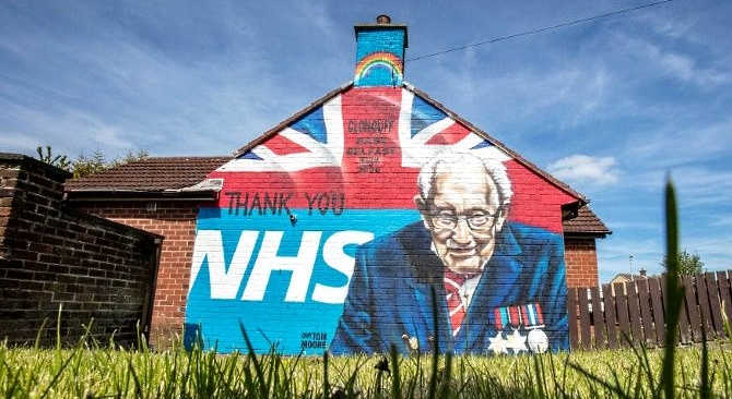 An East Belfast mural shows the NHS logo and an image of 100-year-old British army veteran Captain Tom Moore who raised over 30 million pounds for NHS charities. AFP
