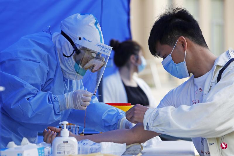 武汉5月9日出现新增确诊病例，为36天来首次。图为当天武汉医护人员在为教师群体进行病毒检测。（图：中新社）