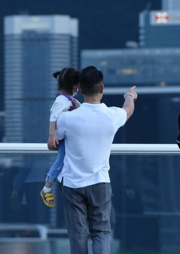 郭富城抱着女儿欣赏维港景色，父与女的背影成好美的构图。