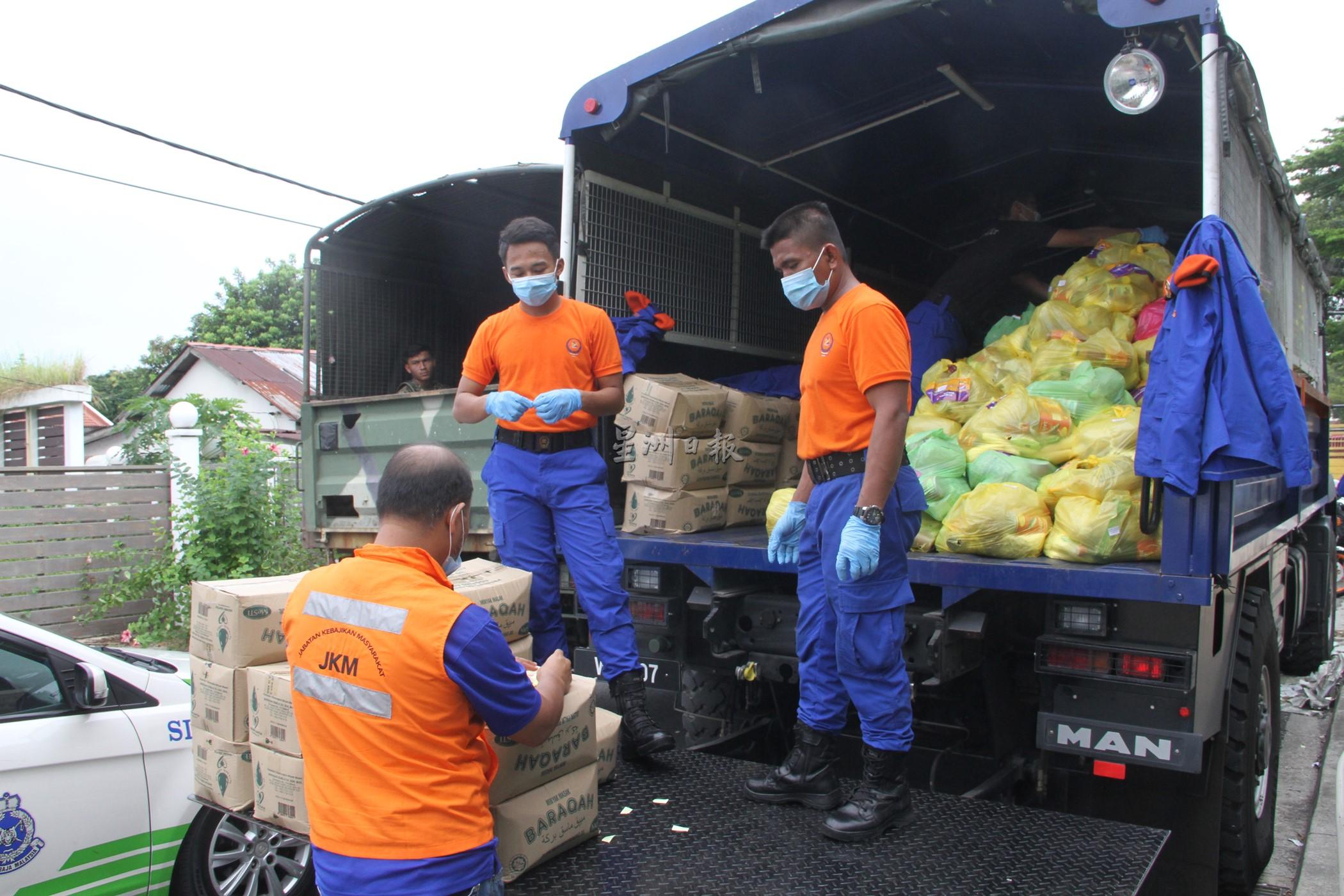 民防部队成员在罗里上分配乾粮，准备派送给封锁范围内的居民。